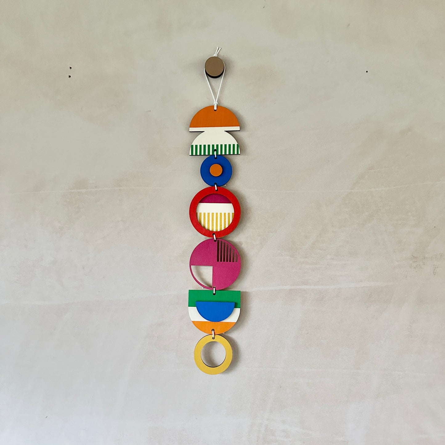 Style 3 of the wall hangings in a rainbow colour palette made from wood cut in to geometric shapes.