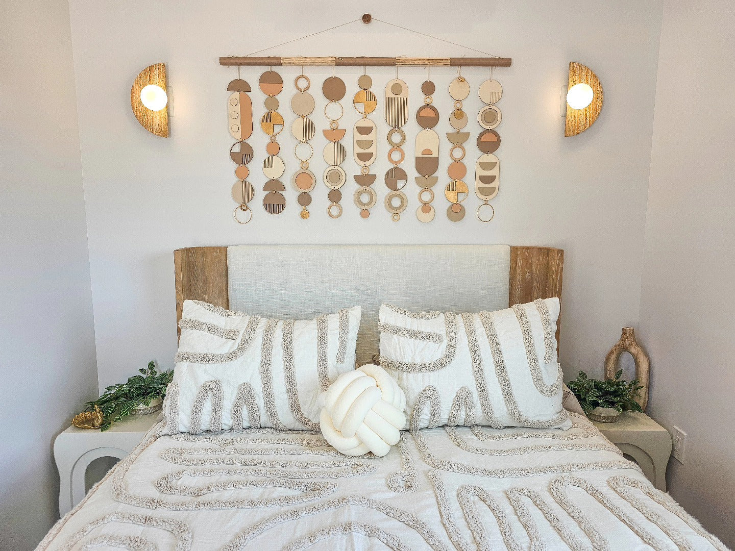 neutral wall hanging above a bed in a bohemian themed style room. 