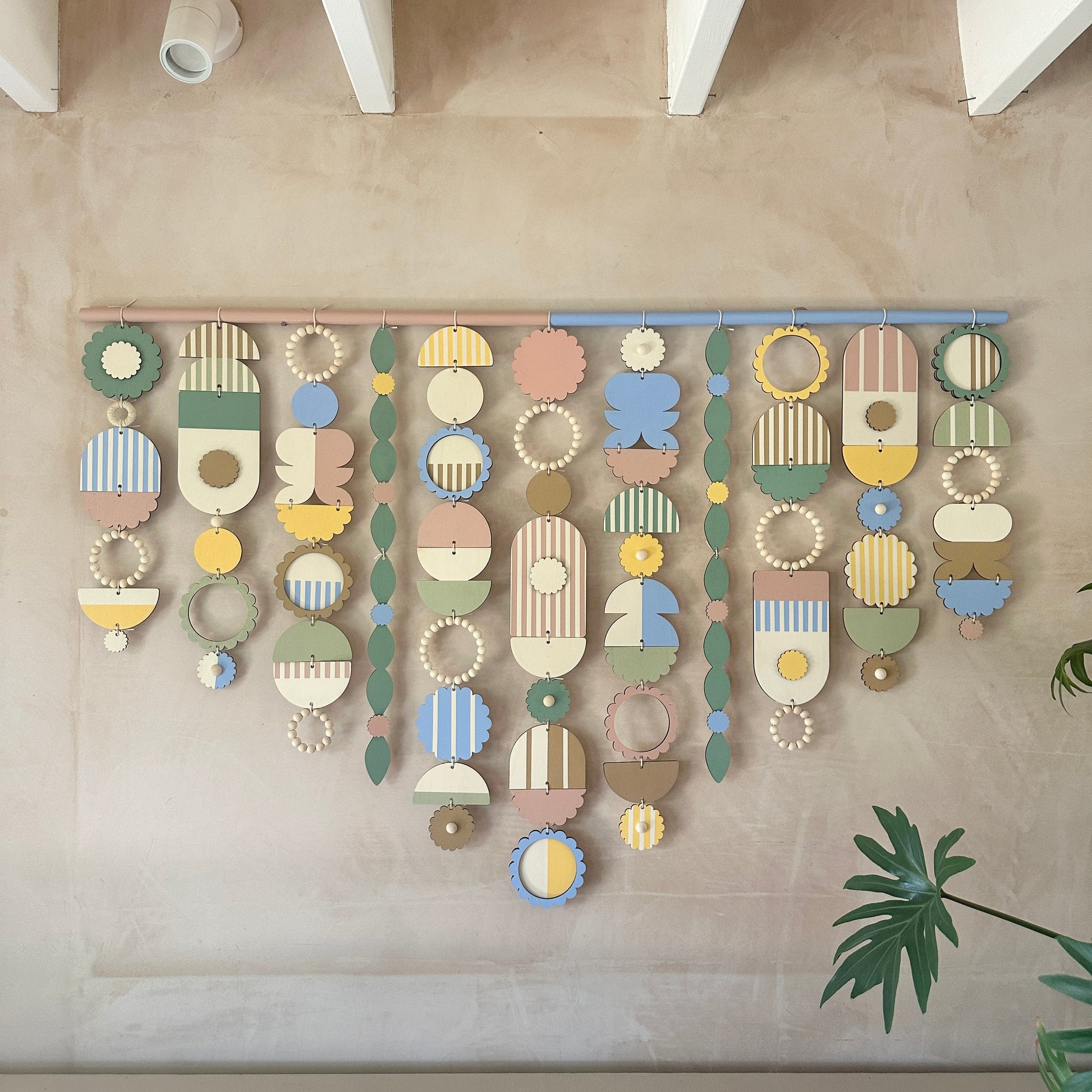 A decorative wall hanging showcasing a lively mix of geometric shapes in bright colors, adding flair to any space.