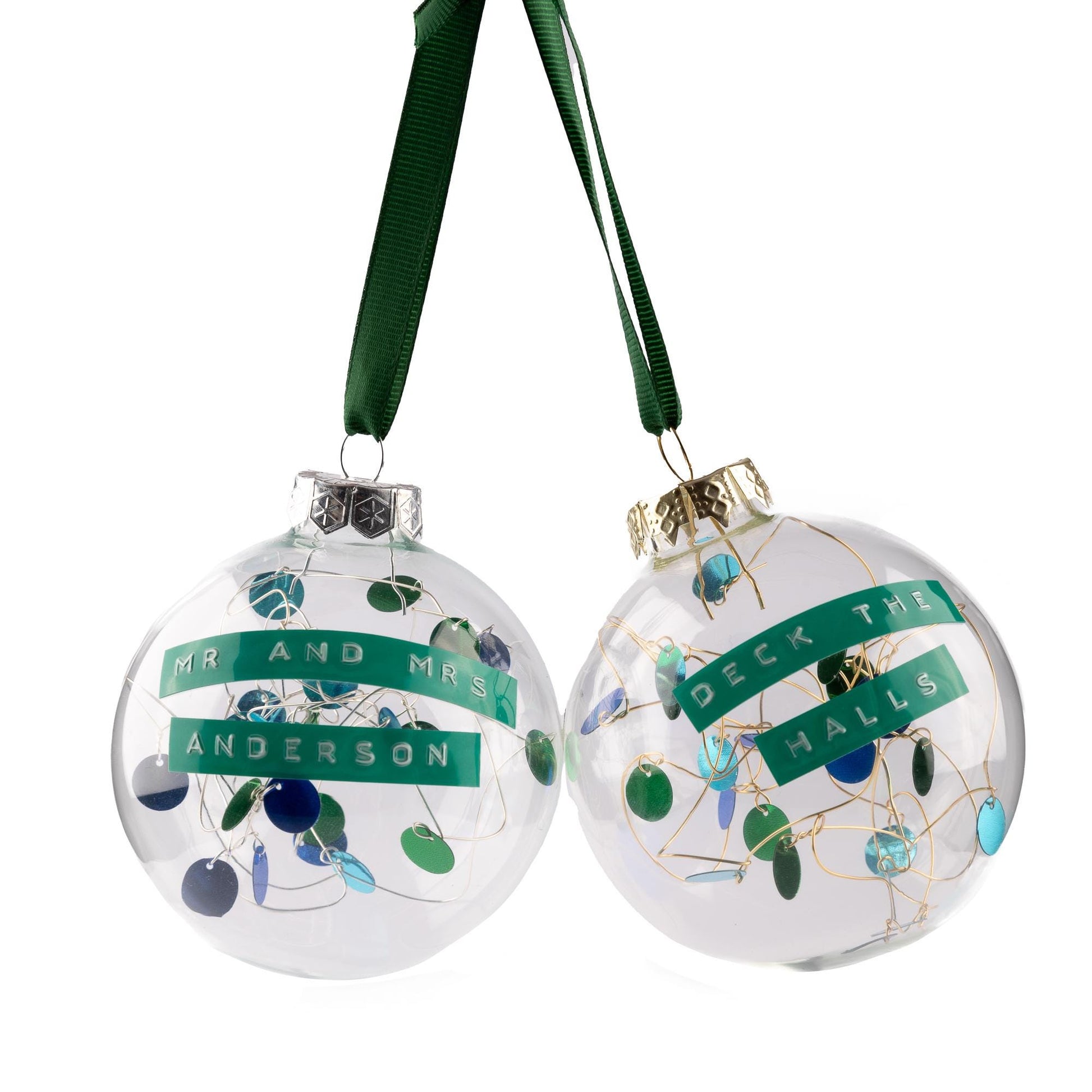 Glass baubles with green and blue sequins on silver or gold wire with a green ribbon to hang it from. With a personalised message embossed on green tape.