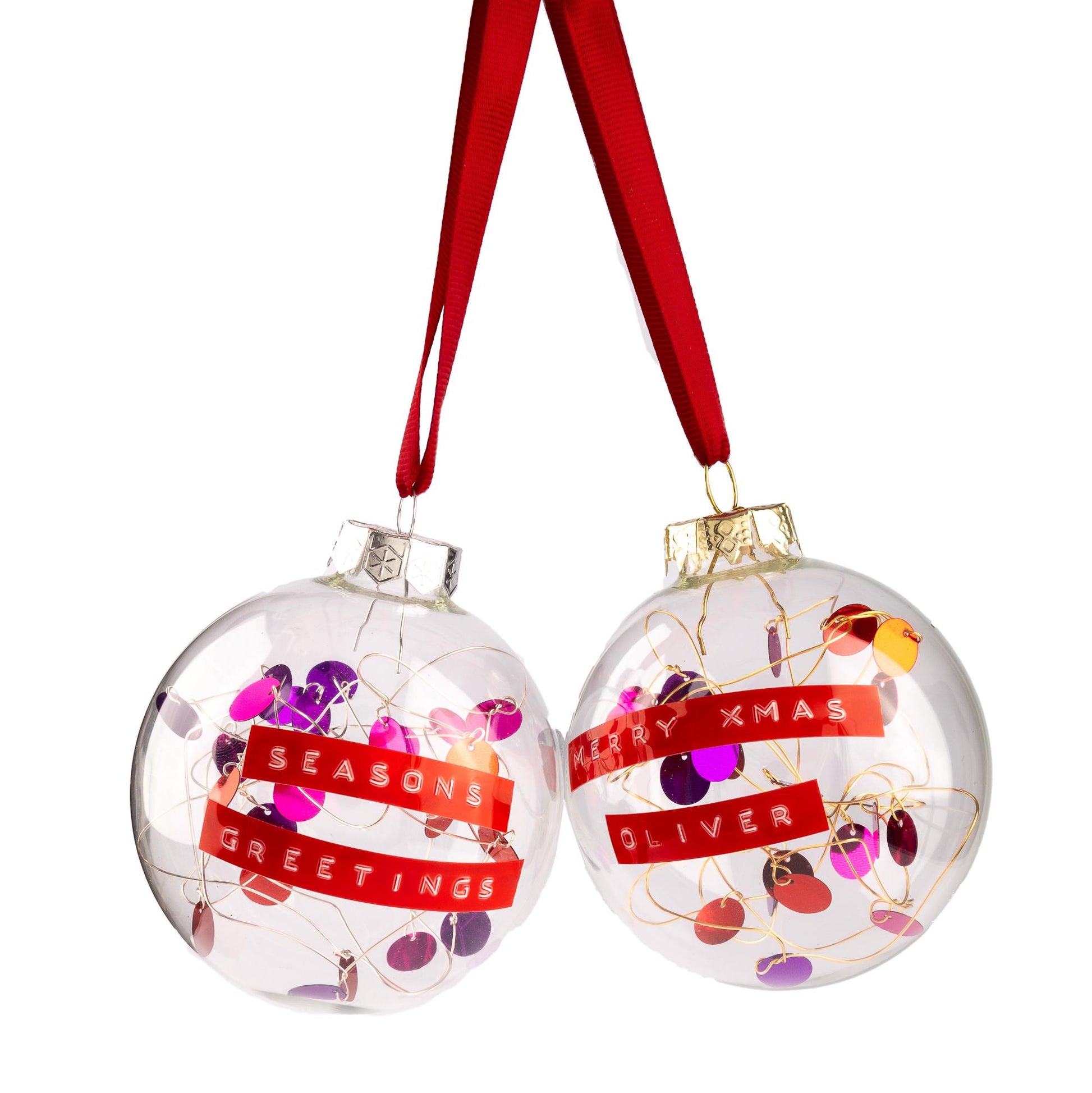 Two glass baubles with red and purple sequins on silver or gold wire with red ribbon. With a personalised message written on red tape.