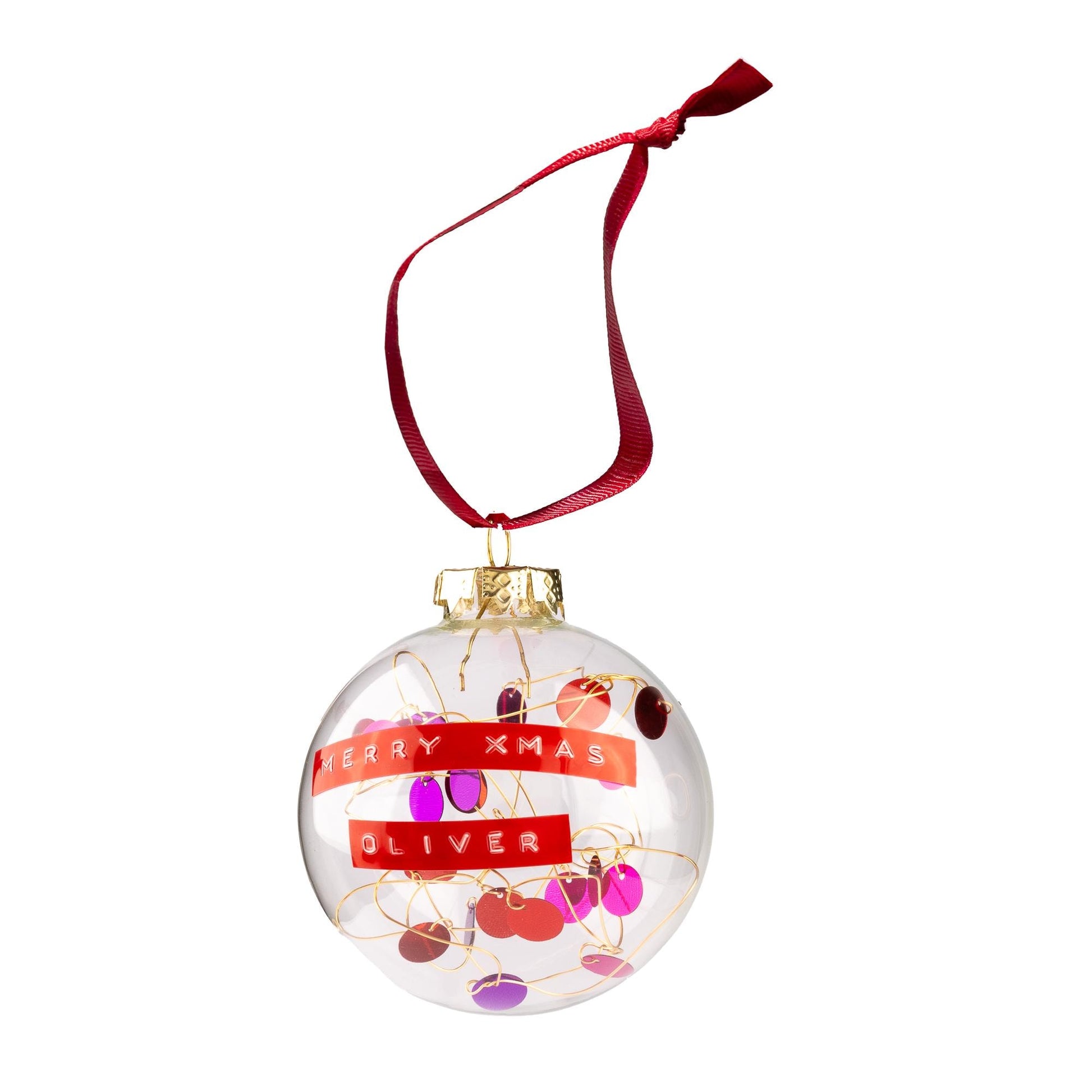 A glass bauble with red and purple sequins on gold wire with a red ribbon to hang it from. With a personalised message written on red tape.