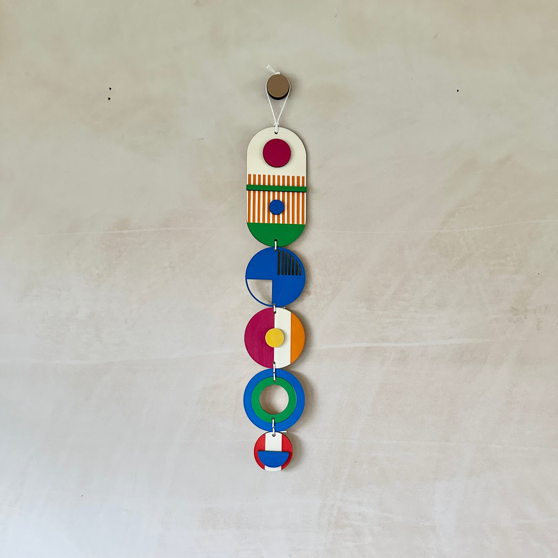 Style 2 of the wall hangings in a rainbow colour palette made from wood cut in to geometric shapes. 